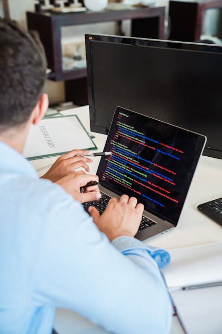 Close-up image showing a computer screen displaying lines of programming code with syntax highlighting in green, blue, purple, and white text on a dark background. The code includes references to data